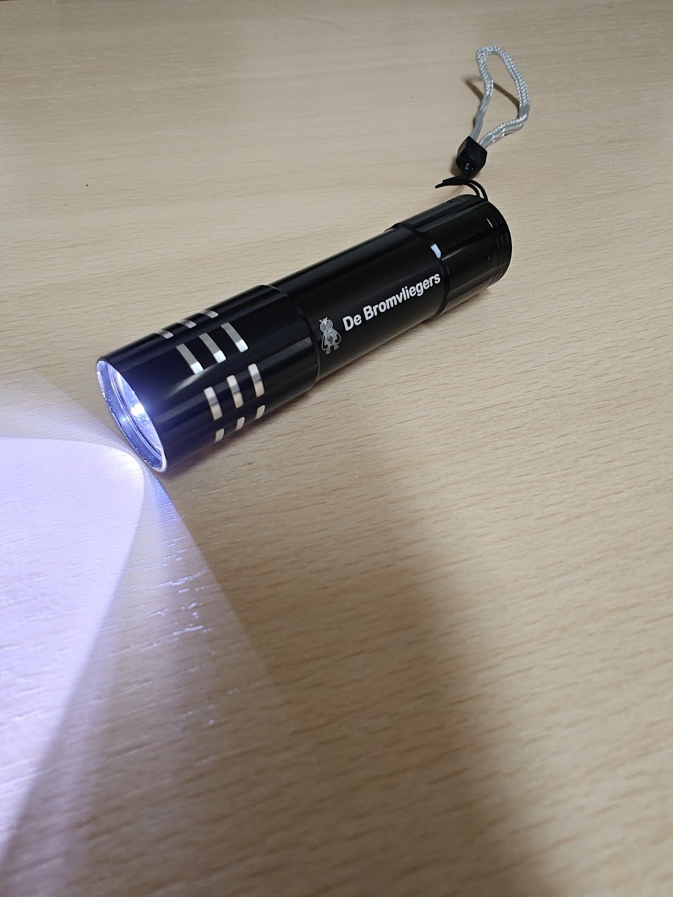 Zaklamp met het logo van De Bromvliegers